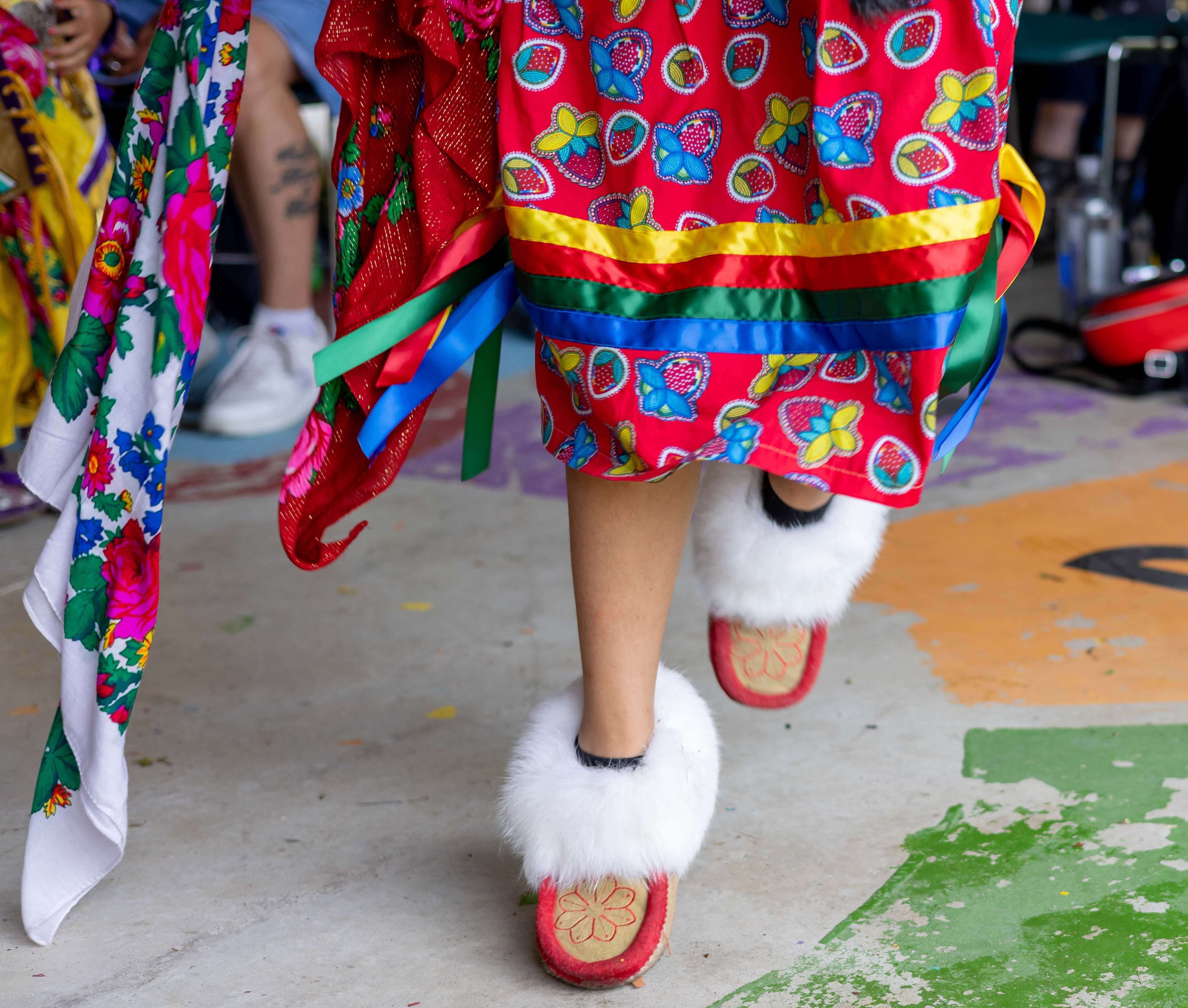 An individual in traditional Indigenous clothing a footwear dance.