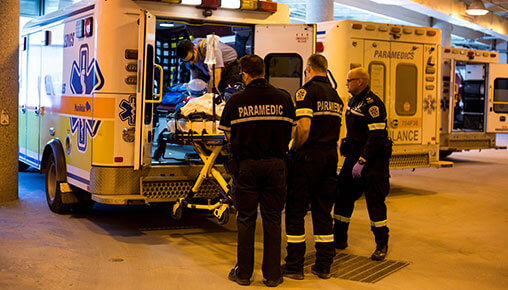 paramedics load a stretcher into an ambulance